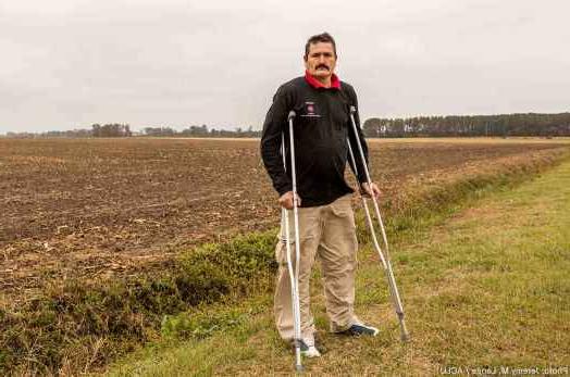 阿图罗·埃尔南德斯拄着拐杖站在北卡罗来纳州的田野里.